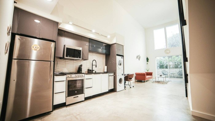 A modern Miami condo kitchen and loft featuring counter-depth appliances and integrated stacked laundry.